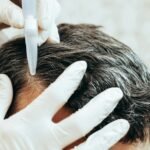 A cosmetologist performs anti-aging procedures, applies hyaluronic acid serum to the scalp