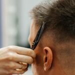 European man is cut by a barber. Men's hair cutting with scissors in the salon