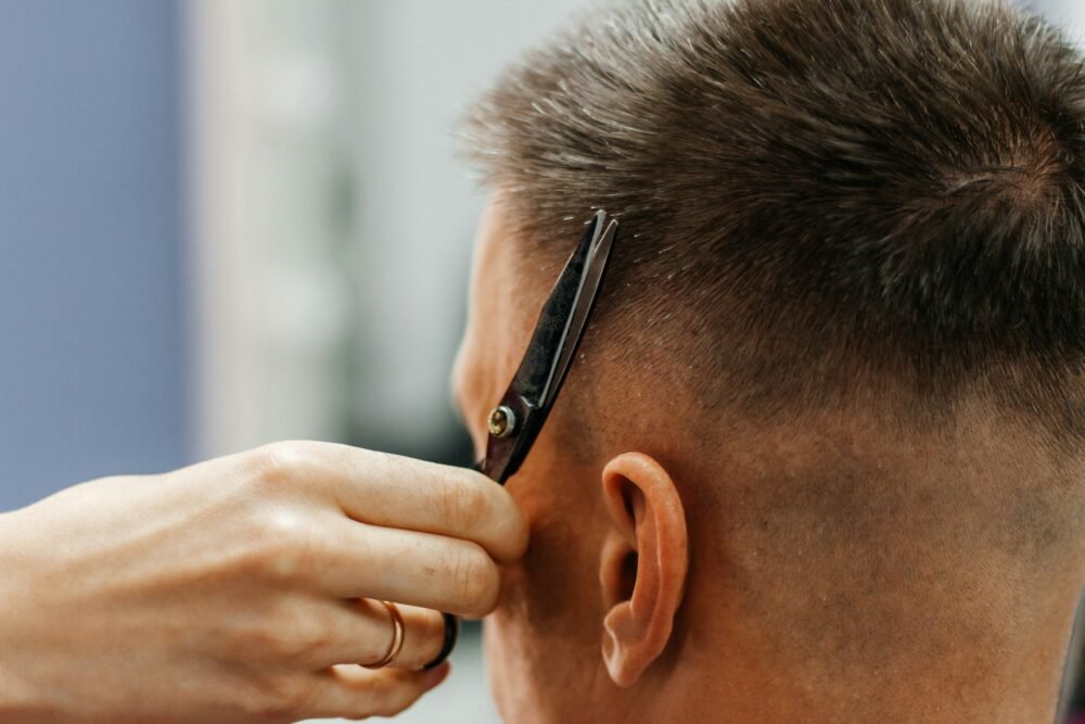 European man is cut by a barber. Men's hair cutting with scissors in the salon