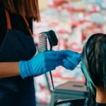 Hairdresser colouring hair of woman