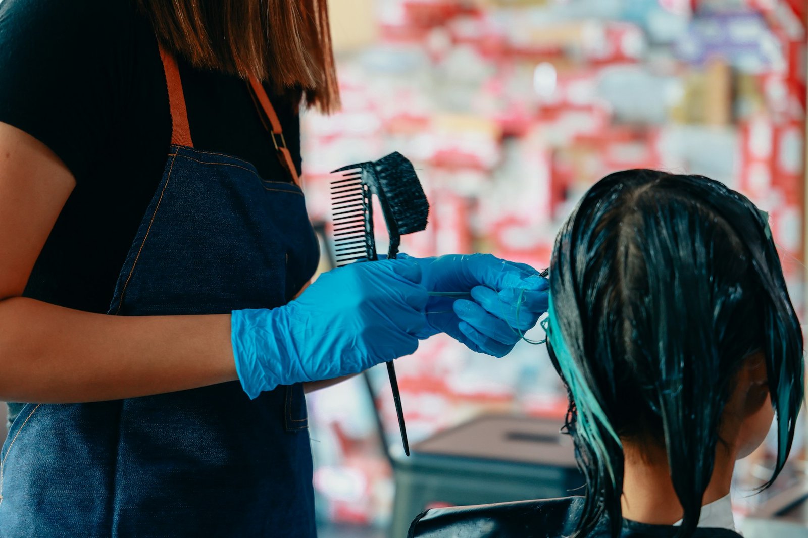 Hairdresser colouring hair of woman