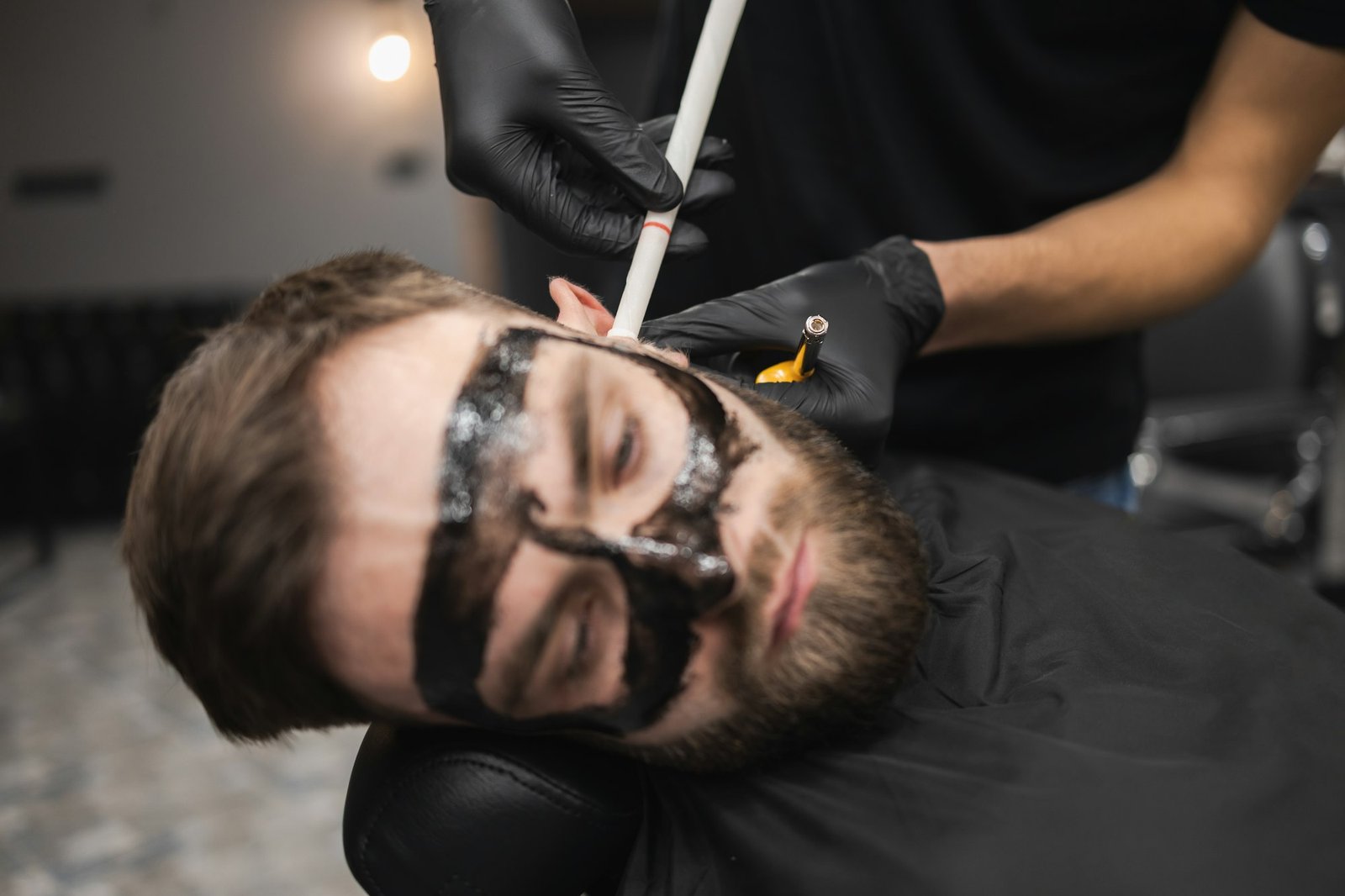 Man in a beauty salon is removing earwax using candles. Male enjoying a spa treatment