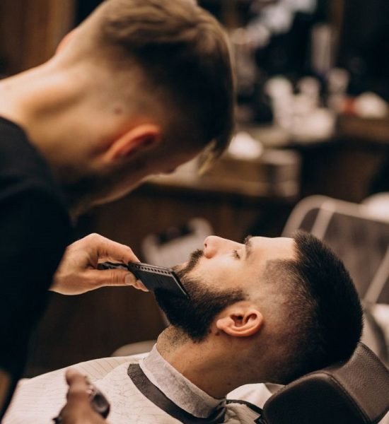 Homem em um salão de barbearia, fazendo o corte de cabelo e barba _ Foto Grátis