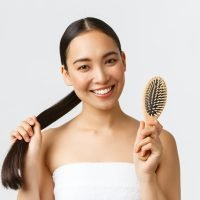 Beauty, hair loss products, shampoo and hair care concept. Close-up of happy attractive asian woman