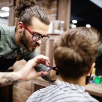 Client during beard and moustache grooming in barber shop