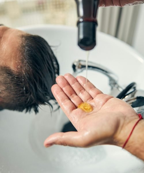 Close up of male hand pouring down shampoo