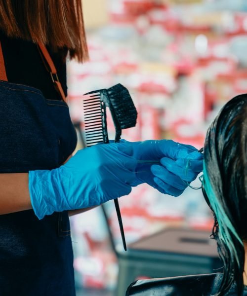 Hairdresser colouring hair of woman