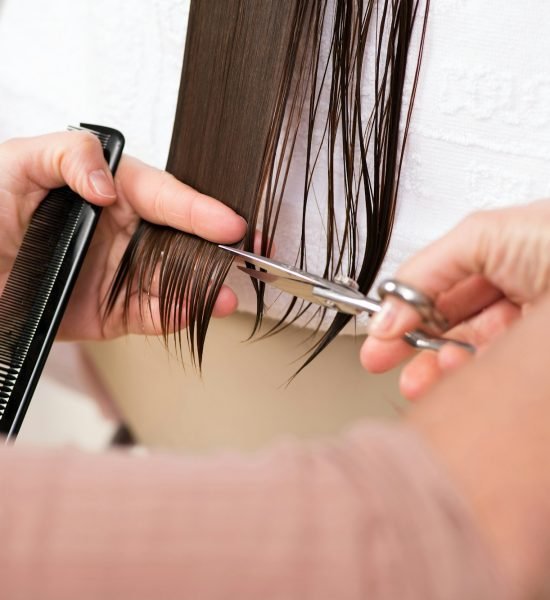 Hairdresser trimming the end of a ladies hair